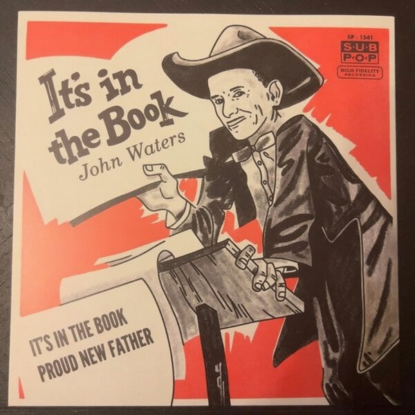 John Waters – It’s In The Book (7″, Single, Gol) (Mint (M)) – 4201271640